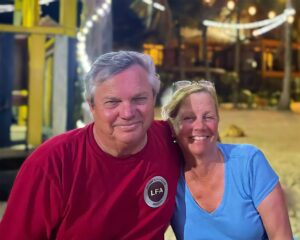 Smiling couple posing together outdoors at night.
